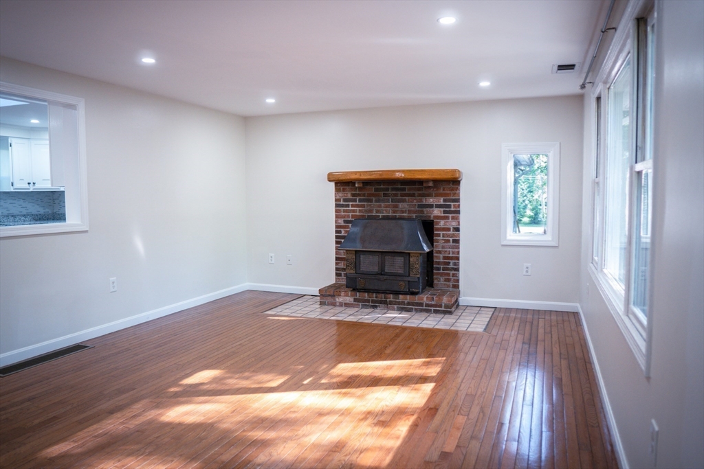24 Little John Road Falmouth, MA 02536 - Photo 8 of 34 a view of an empty room with wooden floor fireplace and a window