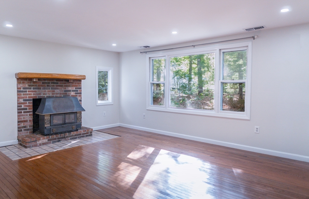 24 Little John Road Falmouth, MA 02536 - Photo 9 of 34 a view of empty room with wooden floor and fireplace