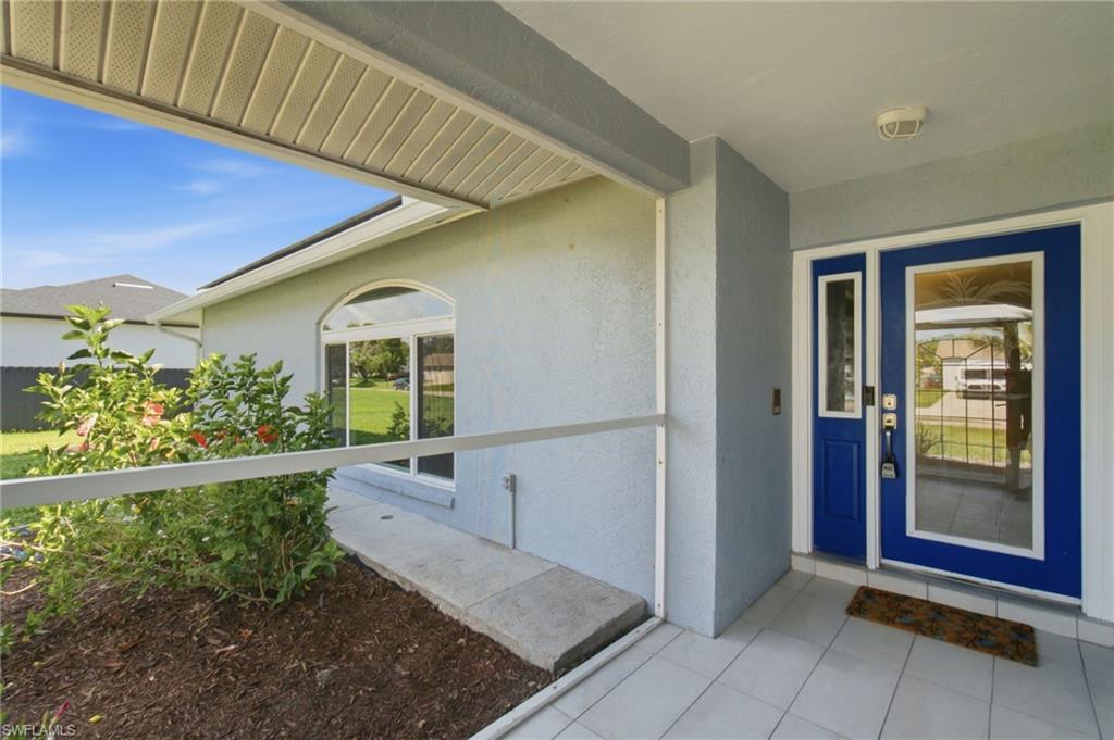 3022 47th Street Southwest Naples, FL 34116 - Photo 4 of 46 Front entrance featuring a vibrant blue double door with glass inserts and a coordinating sidelight