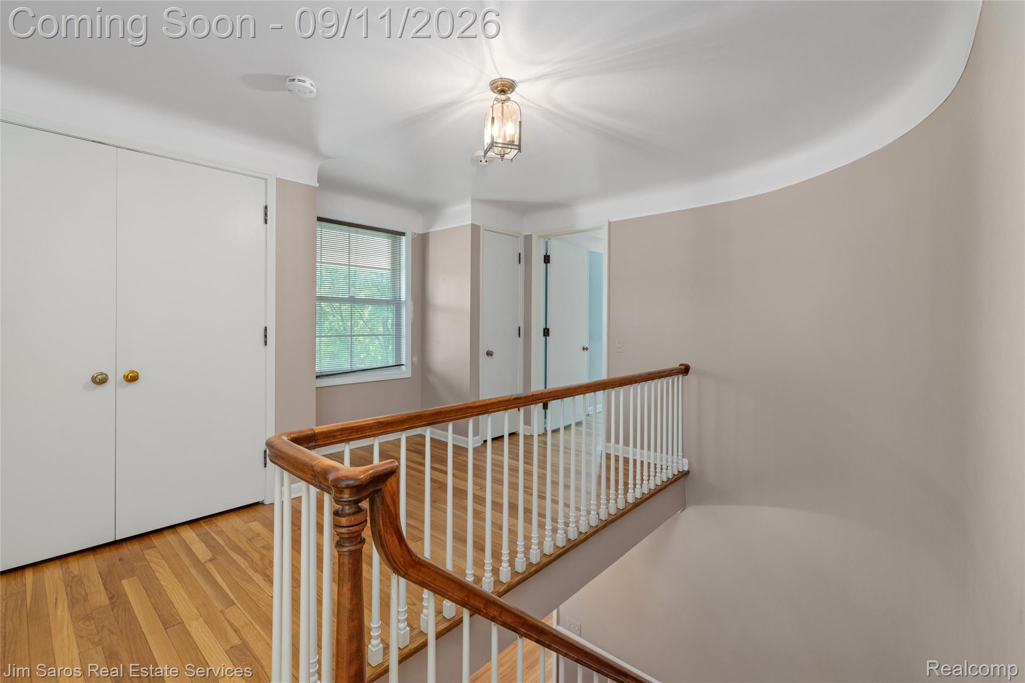 1445 Devonshire Road Grosse Pointe, MI 48230 - Photo 15 of 30 Wood-finish flooring, white spindle railing, paneled interior doors, and a ceiling-mounted light fixture