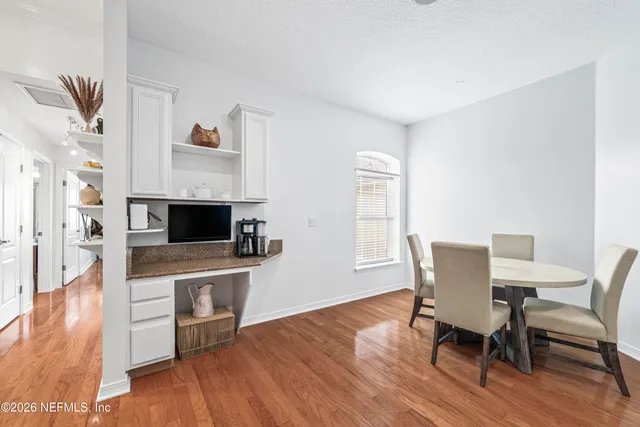 a view of a dining room with furniture wooden floor and a fireplace