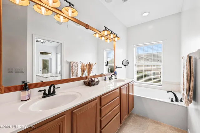 a bathroom with a tub sink and mirror