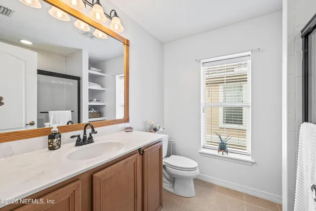 a bathroom with a sink a toilet and a window