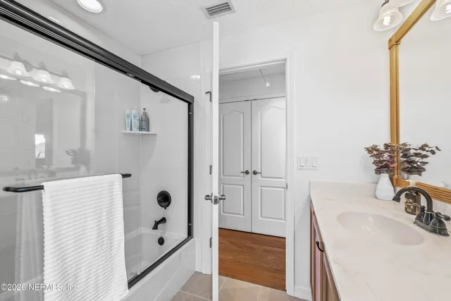 a bathroom with a tub sink and mirror