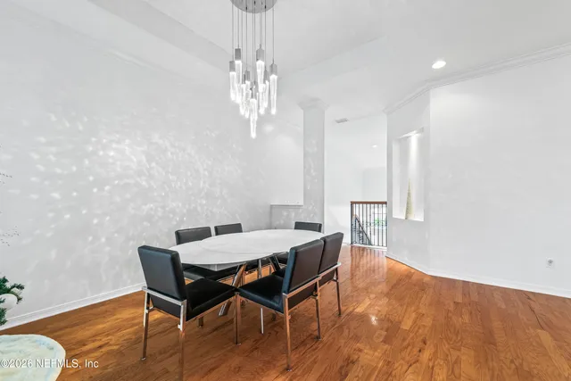 a view of a dining room with furniture a chandelier and wooden floor