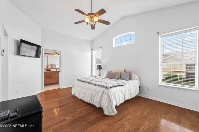 a bedroom with a bed mirror and a window