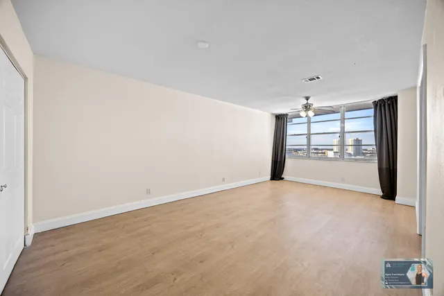 a view of an empty room with closet and entryway