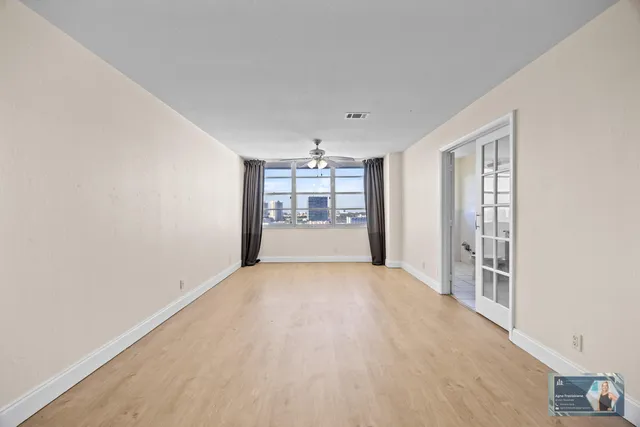 an empty room with a ceiling fan and closet