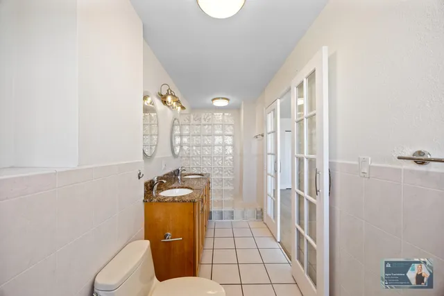 a bathroom with a granite countertop double vanity sink and a mirror
