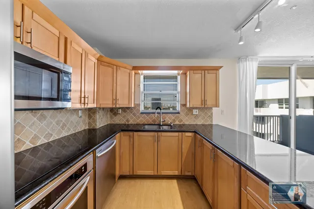 a kitchen with stainless steel appliances granite countertop a stove a refrigerator and a sink