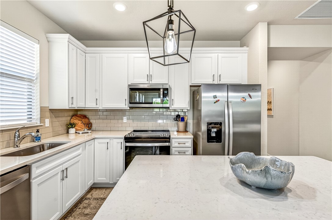 4229 Silver Maple Way Vero Beach, FL 32967 - Photo 12 of 36 a kitchen with stainless steel appliances kitchen island granite countertop a refrigerator a stove a sink and dishwasher