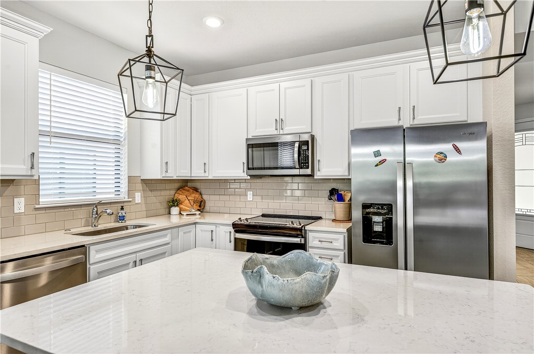 4229 Silver Maple Way Vero Beach, FL 32967 - Photo 13 of 36 a kitchen with stainless steel appliances a stove a sink a refrigerator and cabinets