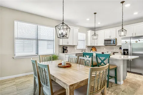a view of a dining room and livingroom with furniture wooden floor and a chandelier