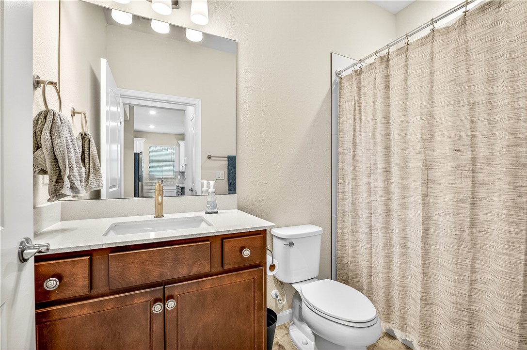 4229 Silver Maple Way Vero Beach, FL 32967 - Photo 23 of 36 a bathroom with a sink a toilet and shower curtain