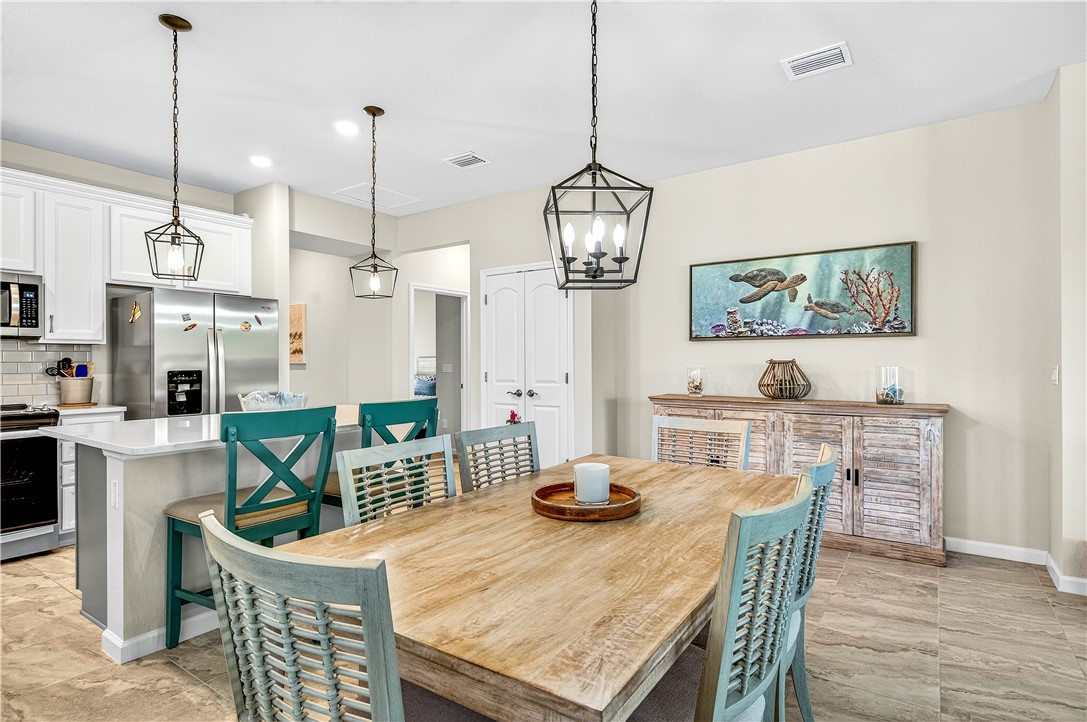 4229 Silver Maple Way Vero Beach, FL 32967 - Photo 4 of 36 a view of a dining room and livingroom with furniture wooden floor a chandelier