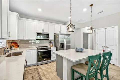 a kitchen with kitchen island a stove a table and chairs