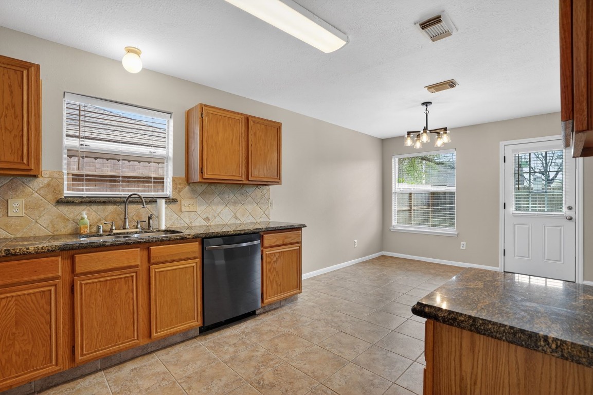 18622 Timbers Drive Humble, TX 77346 - Photo 12 of 34 a kitchen with stainless steel appliances granite countertop wooden cabinets a sink a stove a dining table and chairs