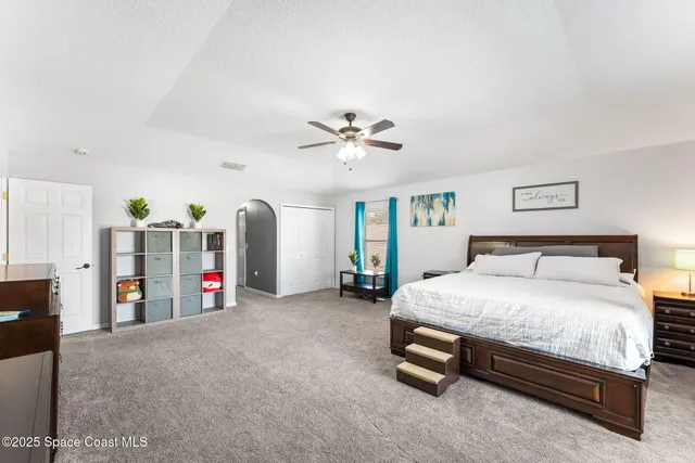 a bed room with a bed and a ceiling fan