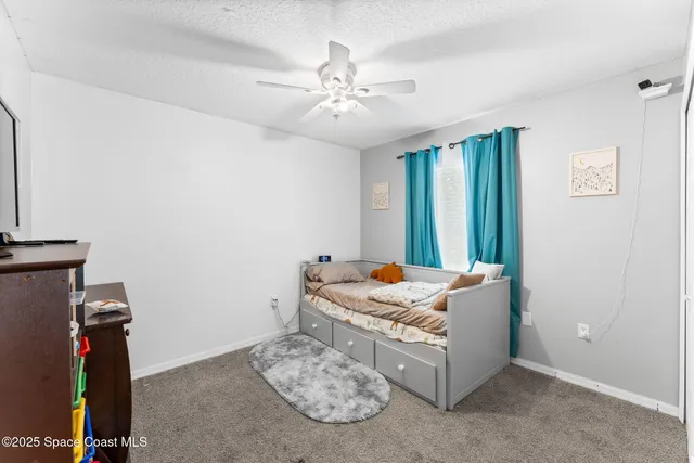 a living room with hard wood floor and a ceiling fan