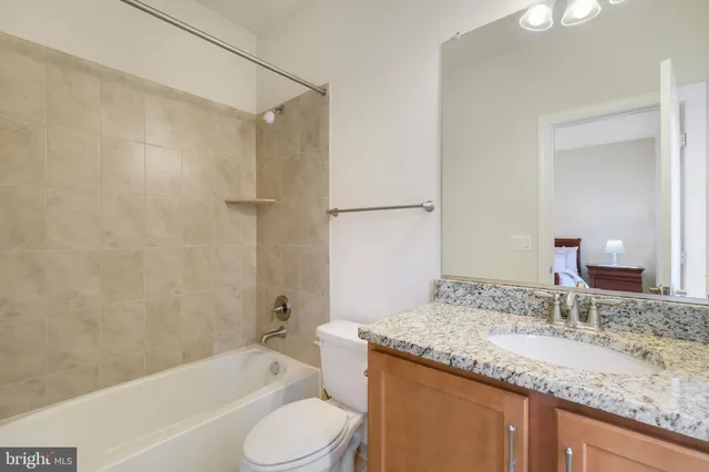 front view of a brick house with a large window and potted plants