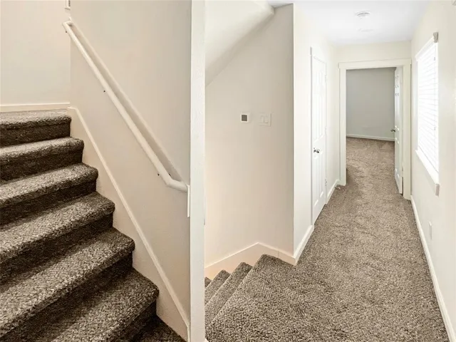 a view of a hallway with wooden floor and entryway