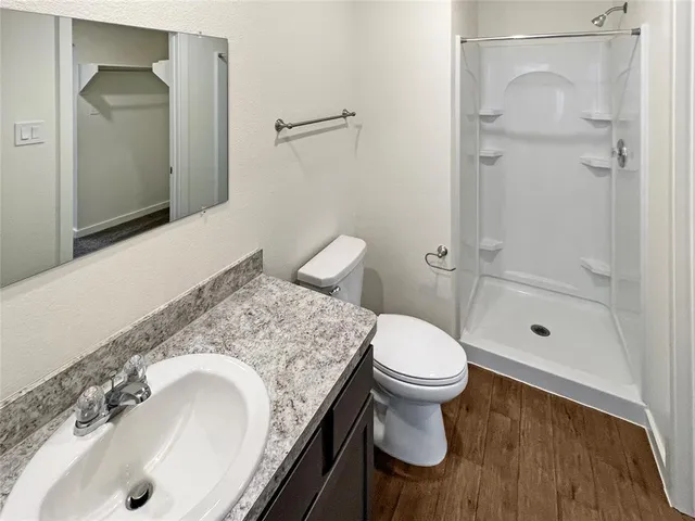a bathroom with a granite countertop sink toilet and shower