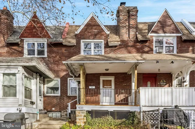 a view of a white house with large windows and a small yard