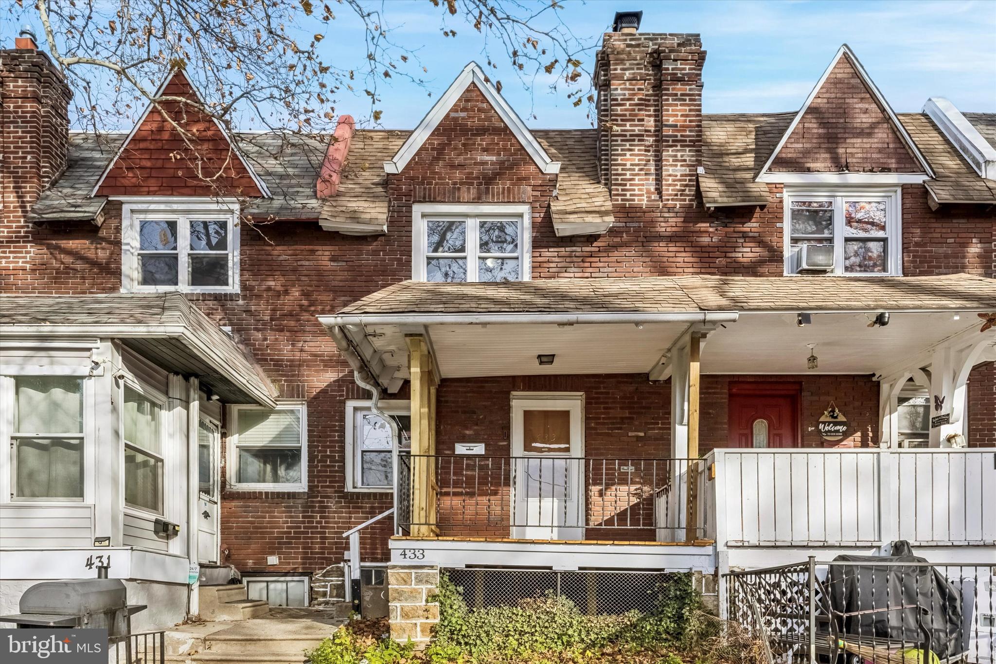 a view of a white house with large windows and a small yard