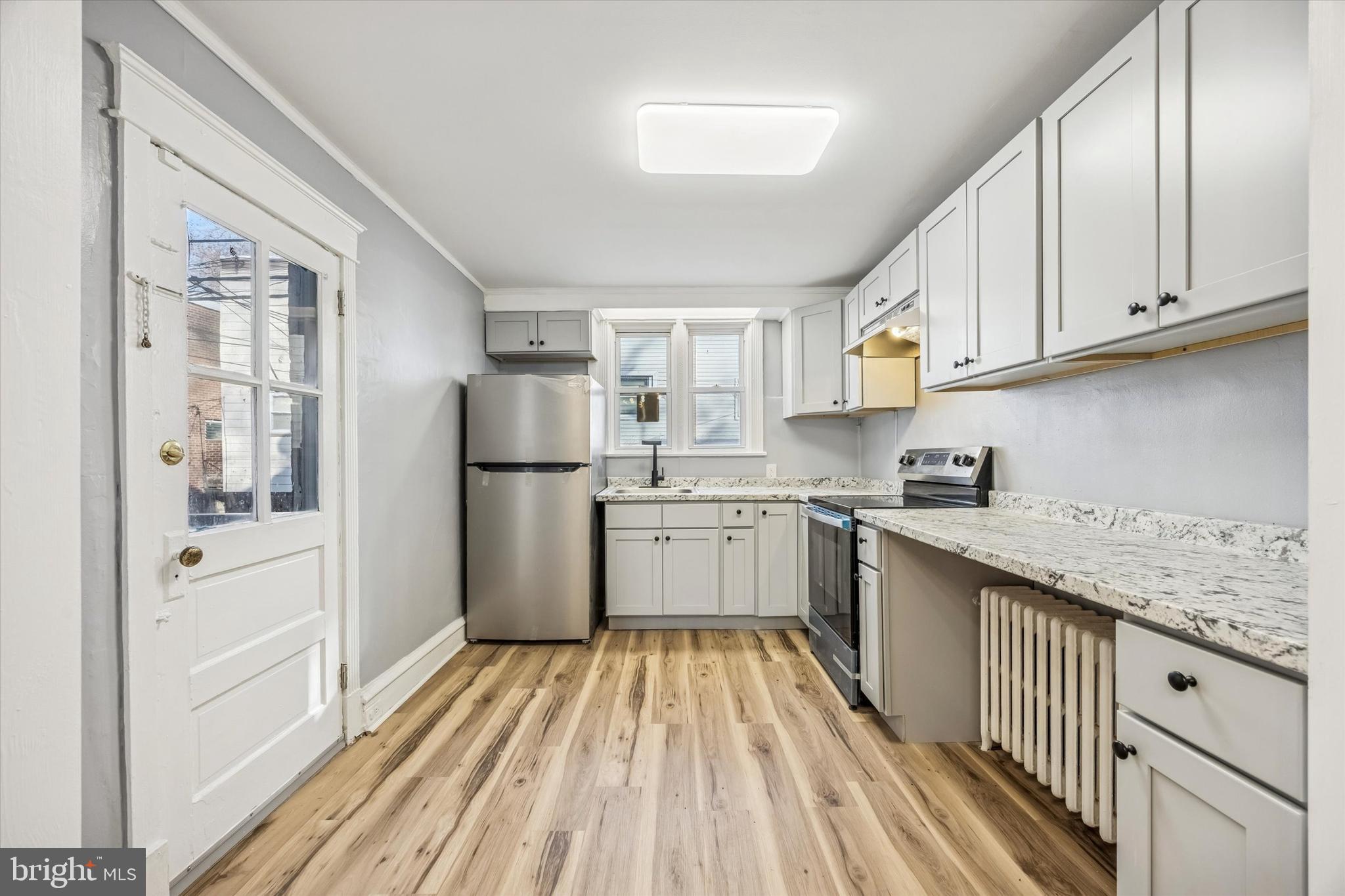 433 Copley Road Upper Darby, PA 19082 - Photo 11 of 35 a kitchen with cabinets oven a sink and a window