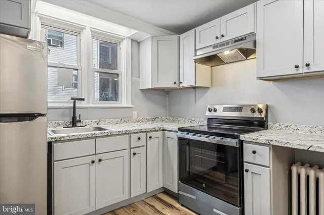 a kitchen with cabinets appliances a sink and a counter space