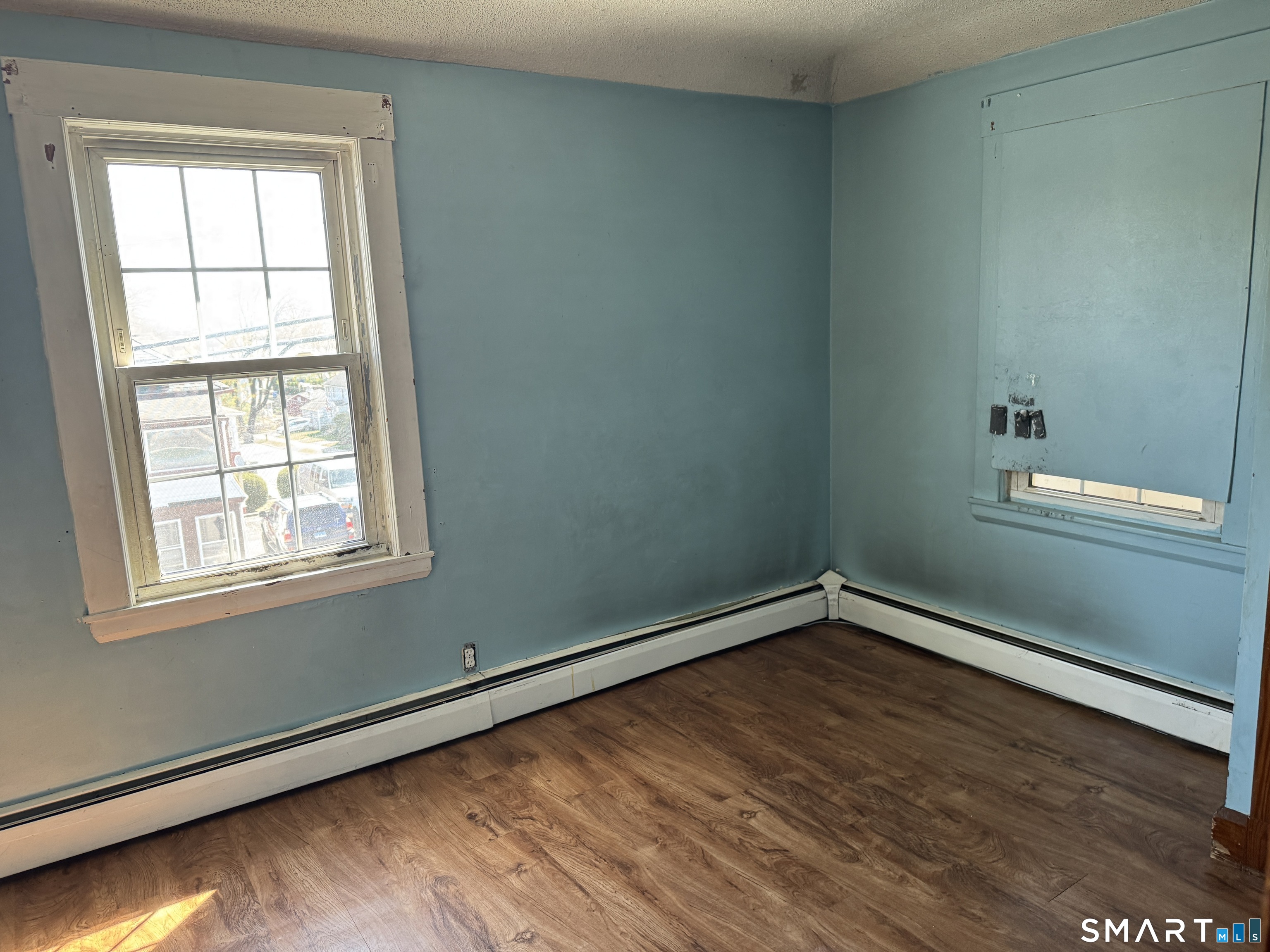 138 Greene Street Bristol, CT 06010 - Photo 17 of 32 an empty room with wooden floor and windows