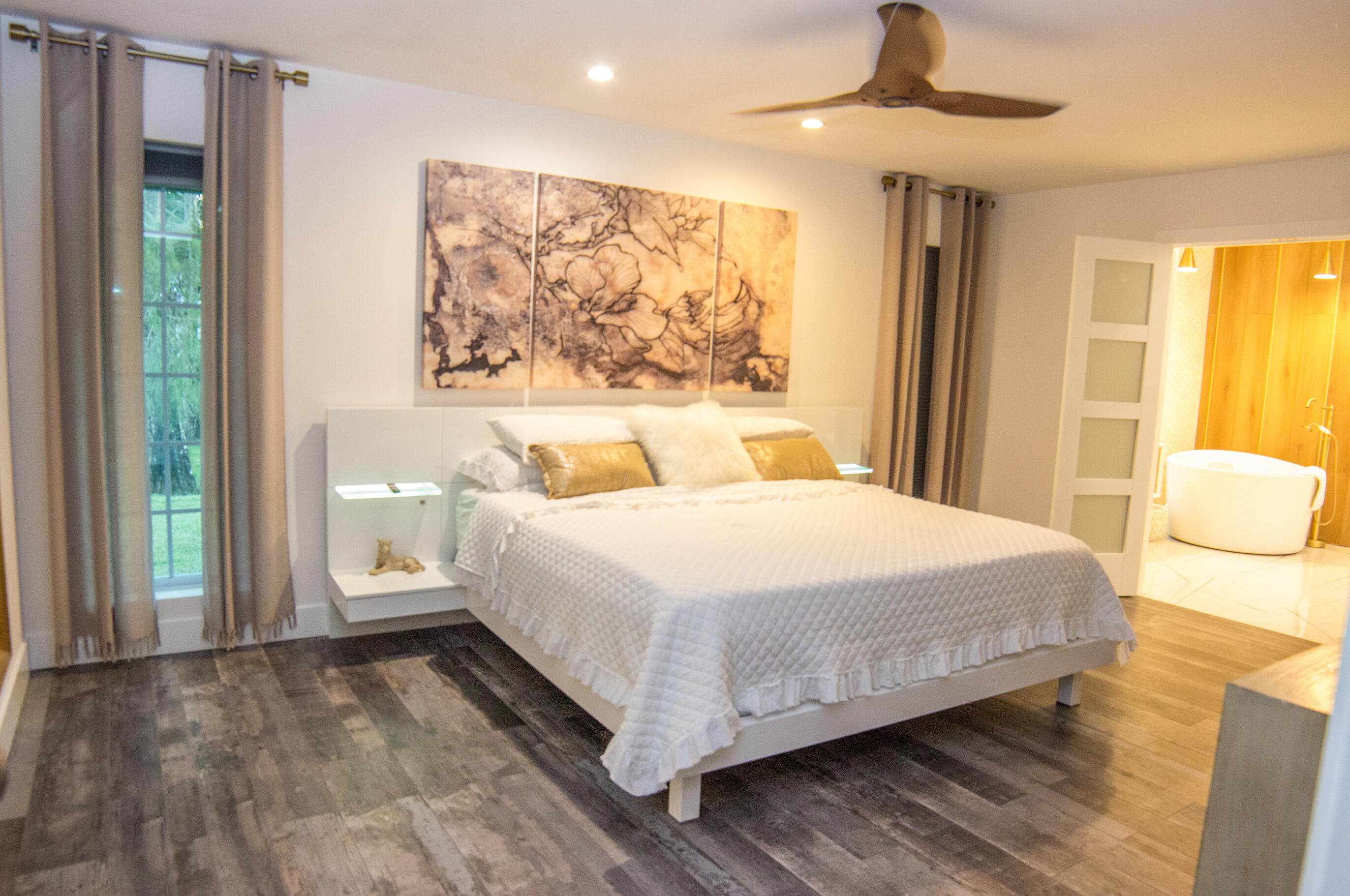 661 West Rambling Drive Wellington, FL 33414 - Photo 25 of 33 a spacious bedroom with a bed and a painting on the wall