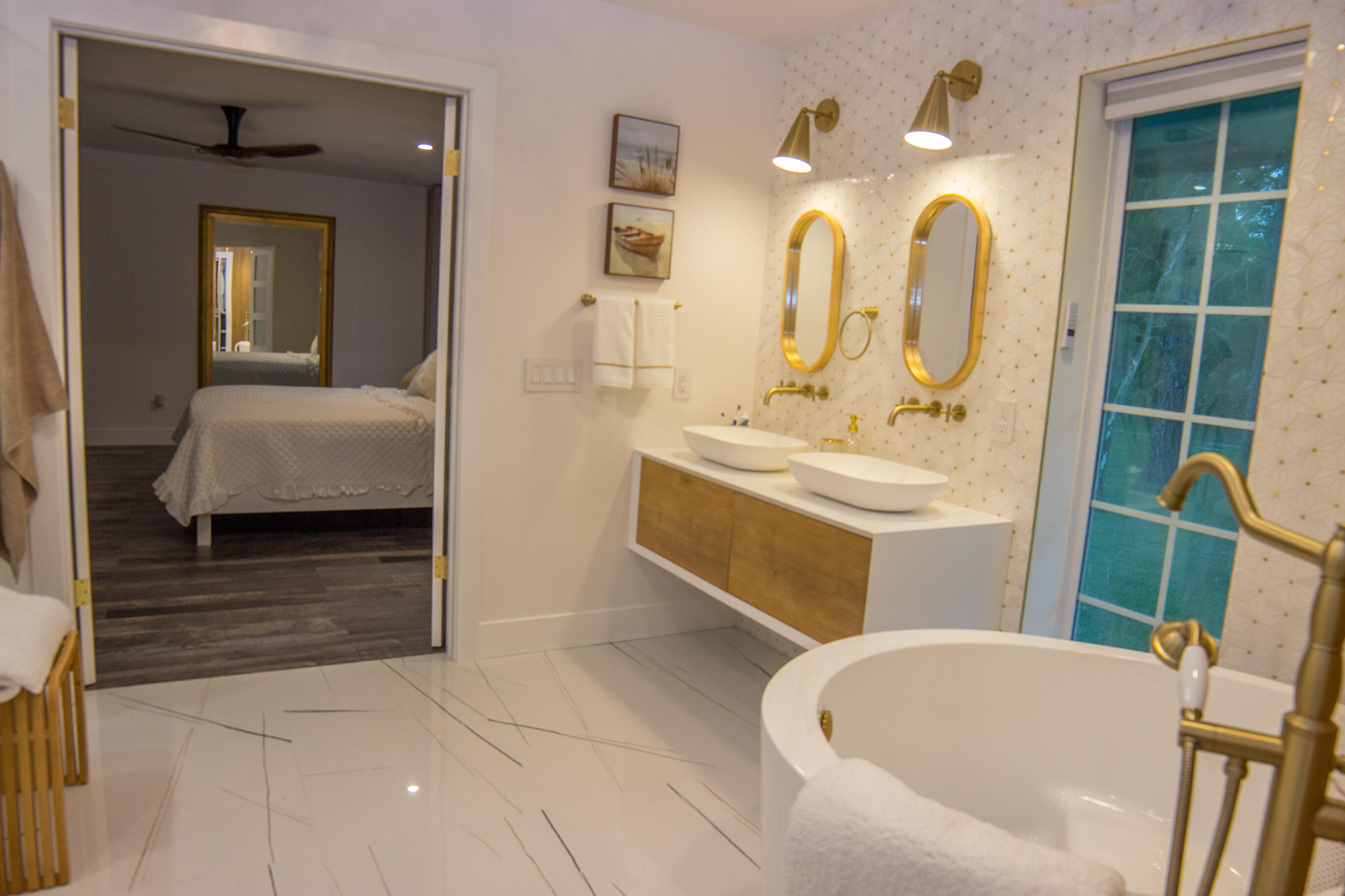 661 West Rambling Drive Wellington, FL 33414 - Photo 26 of 33 a en suite bathroom with a double vanity sink a mirror and a bathtub