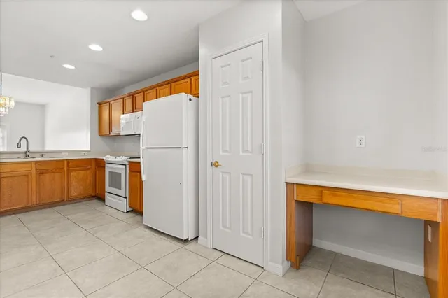 a kitchen with a refrigerator sink and cabinets