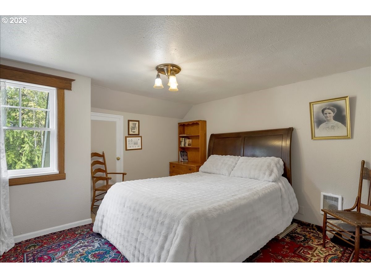 162 Riverside Drive Idanha, OR 97350 - Photo 25 of 37 a bedroom with a bed and a lamp with window