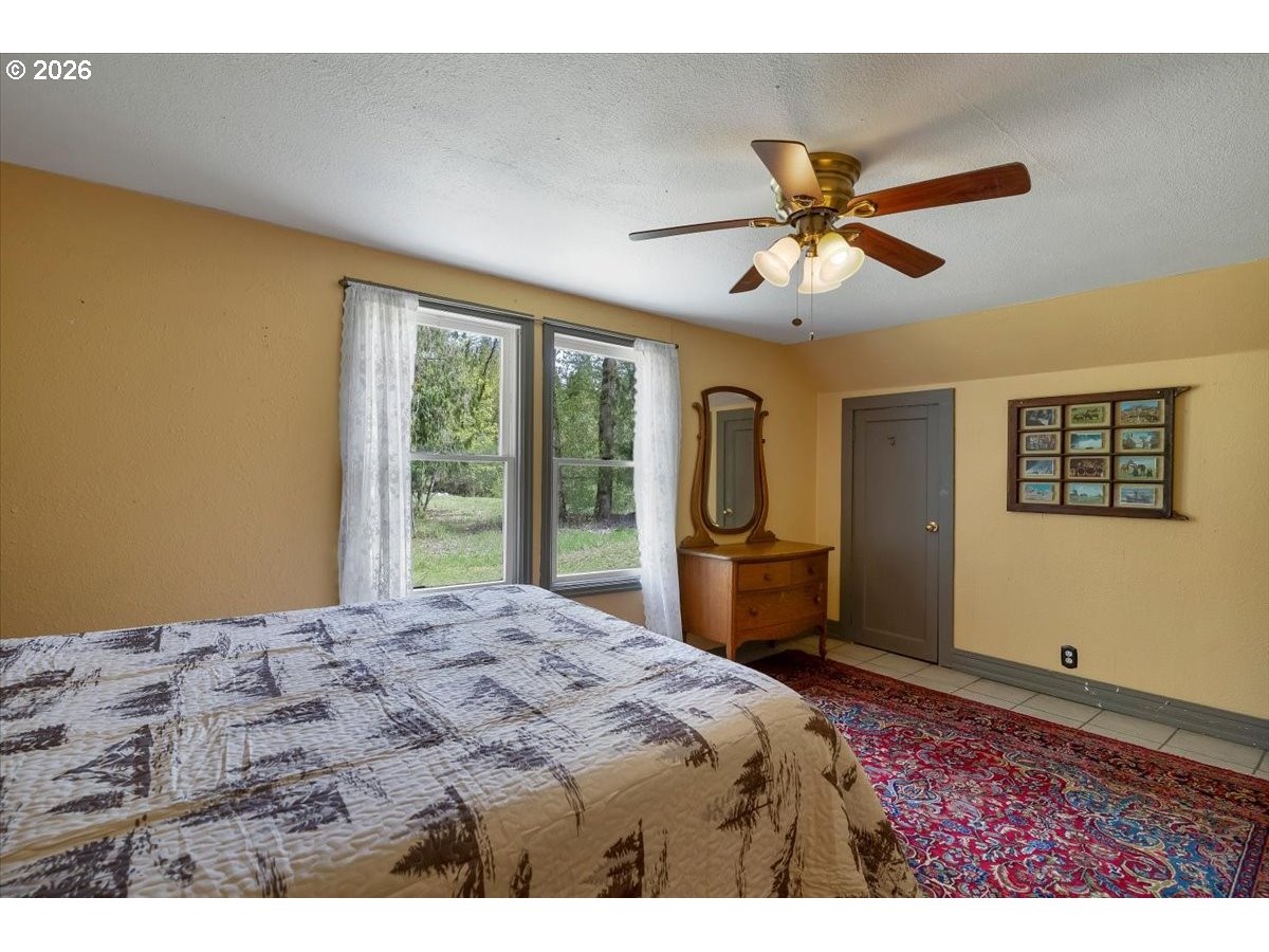 162 Riverside Drive Idanha, OR 97350 - Photo 28 of 37 a bedroom with a large bed and a chandelier