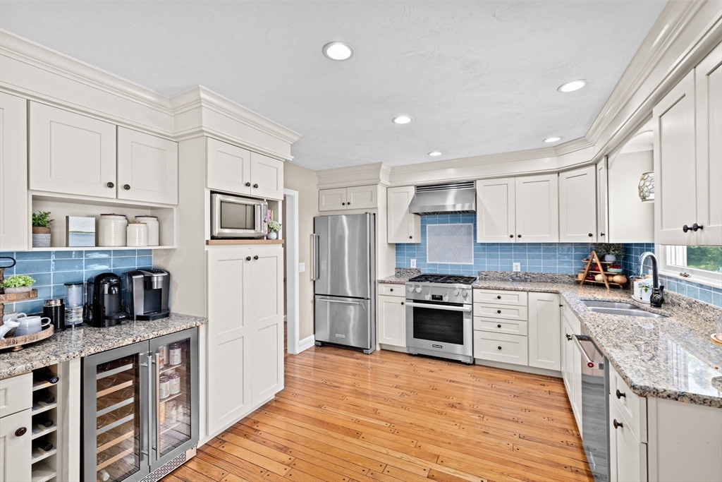 5 Cliff Estates Road Scituate, MA 02066 - Photo 7 of 42 a kitchen with stainless steel appliances granite countertop a stove top oven a sink dishwasher and a refrigerator with wooden floor