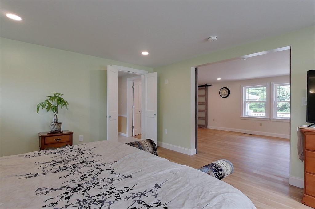 103 Lowell Road Pepperell, MA 01463 - Photo 15 of 42 a bedroom with a bed and a dresser with wooden floor