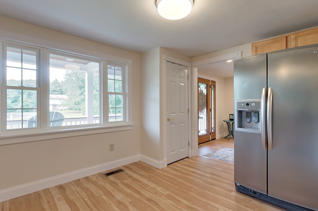103 Lowell Road Pepperell, MA 01463 - Photo 6 of 42 a view of a kitchen with a refrigerator wooden floor and a cabinet
