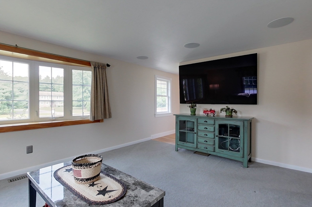 103 Lowell Road Pepperell, MA 01463 - Photo 10 of 42 a living room with furniture and a flat screen tv