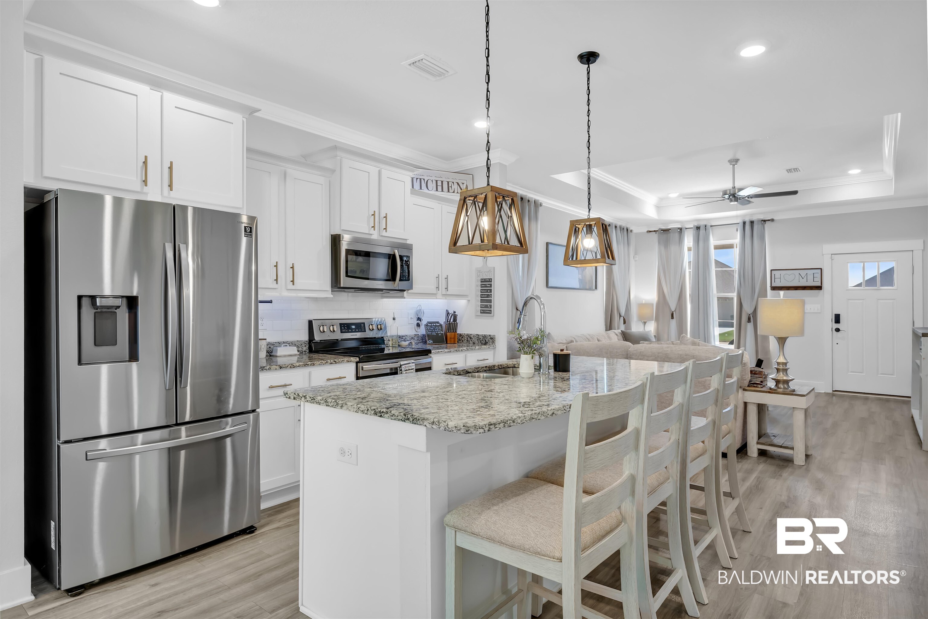 16504 Prado Loop Loxley, AL 36551 - Photo 11 of 45 Kitchen with stainless steel appliances, ornamental molding, light stone countertops, light wood-style flooring, and a center island with sink