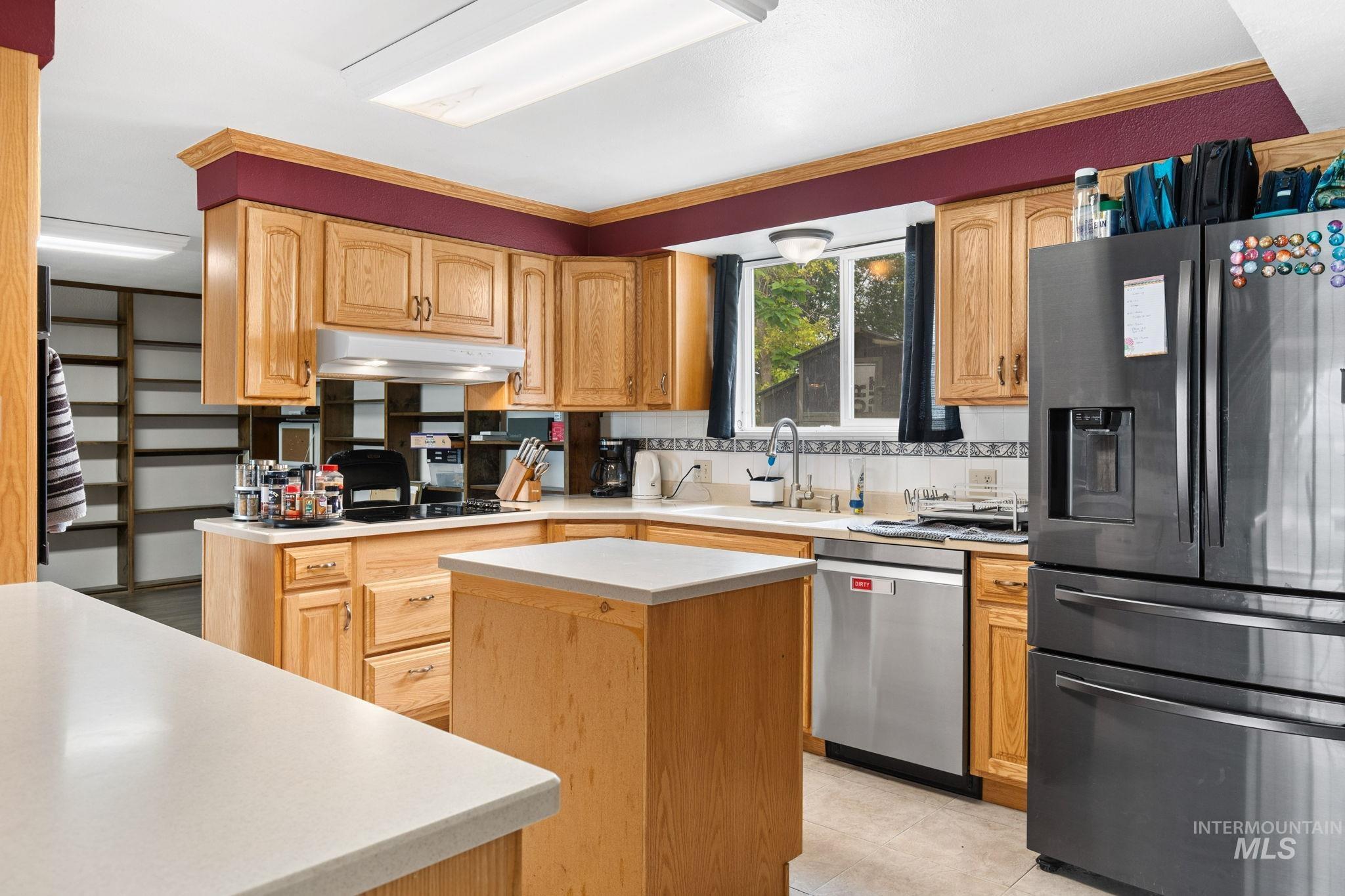 18338 Pride Lane Caldwell, ID 83607 - Photo 11 of 50 Kitchen featuring light wood cabinetry, light countertops, and a full suite of stainless steel appliances
