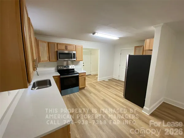a kitchen with granite countertop a refrigerator and a sink
