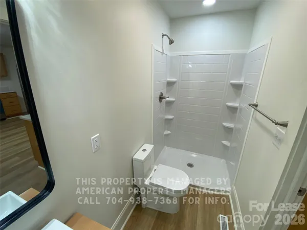 a bathroom with a granite countertop shower and a toilet