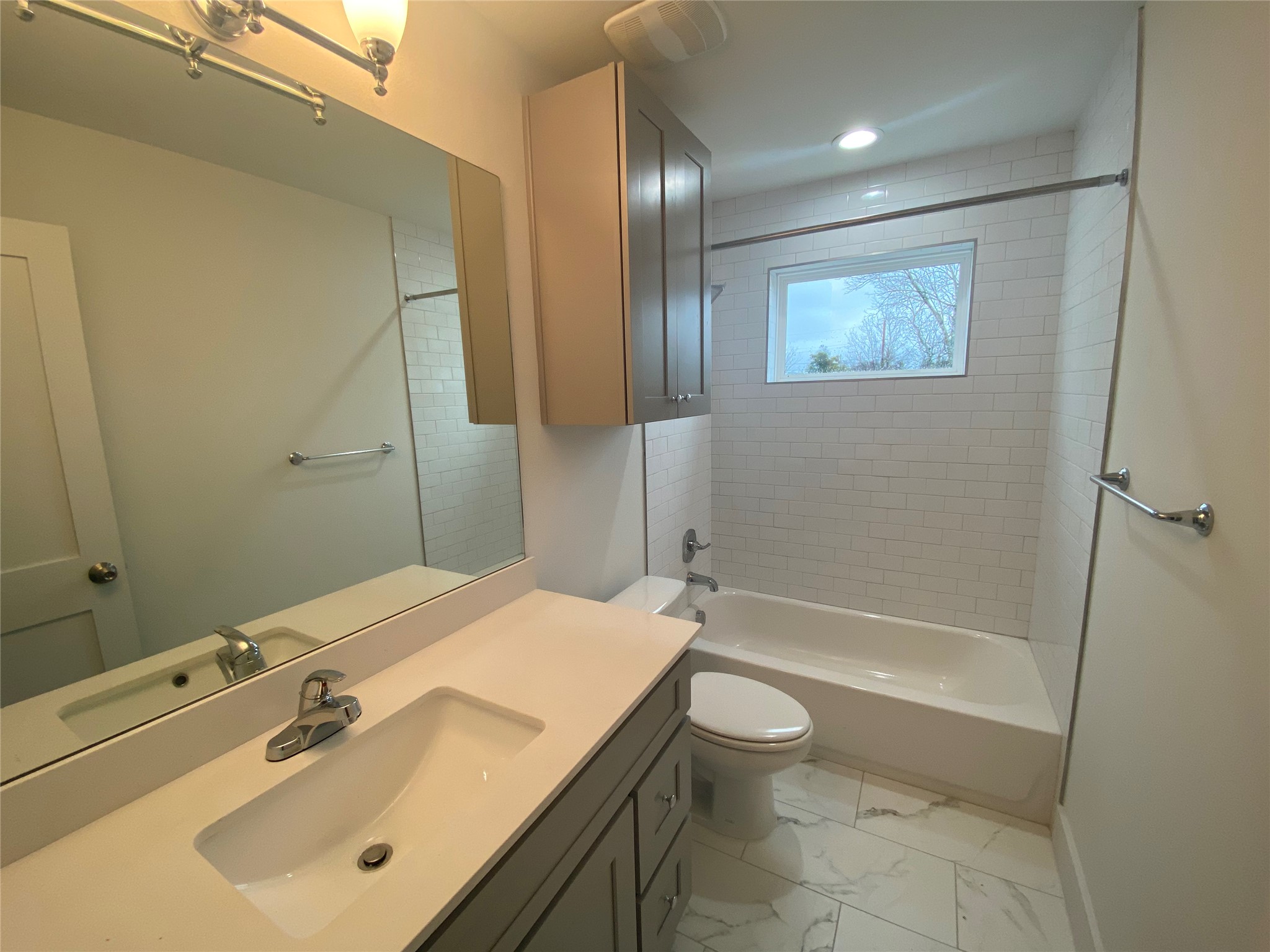 1916 Webberville Road, Unit B Austin, TX 78721 - Photo 4 of 25 Modern bathroom featuring a single vanity with an integrated sink, a large mirror, and overhead lighting