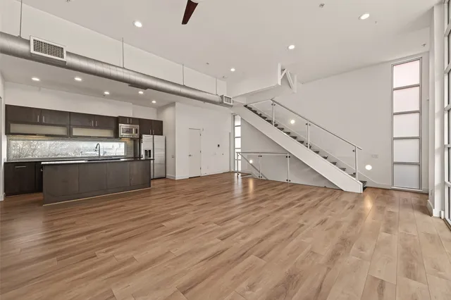 a kitchen with a dining table chairs stainless steel appliances and cabinets