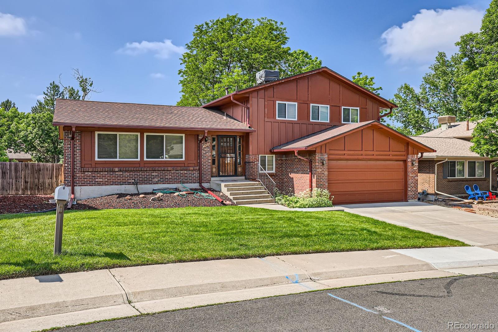 7464 East Colgate Place Denver, CO 80231 - Photo 2 of 7 a front view of a house with a yard and garage