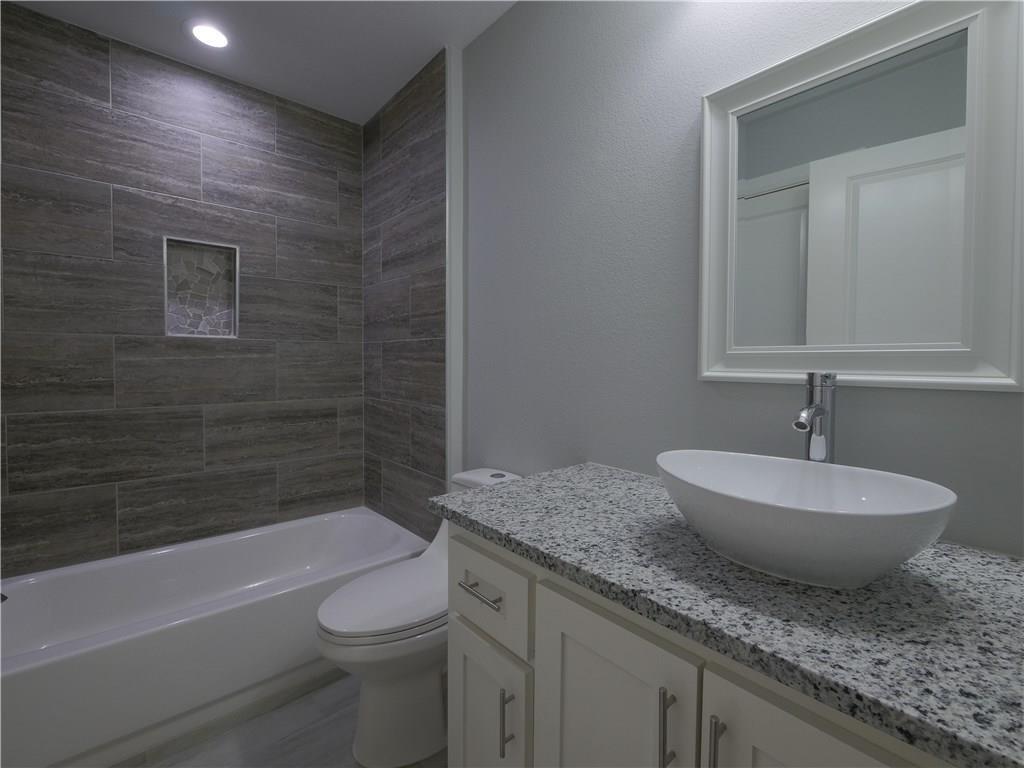 605 East Carter Street Sherman, TX 75090 - Photo 5 of 10 a bathroom with a granite countertop sink toilet and bathtub