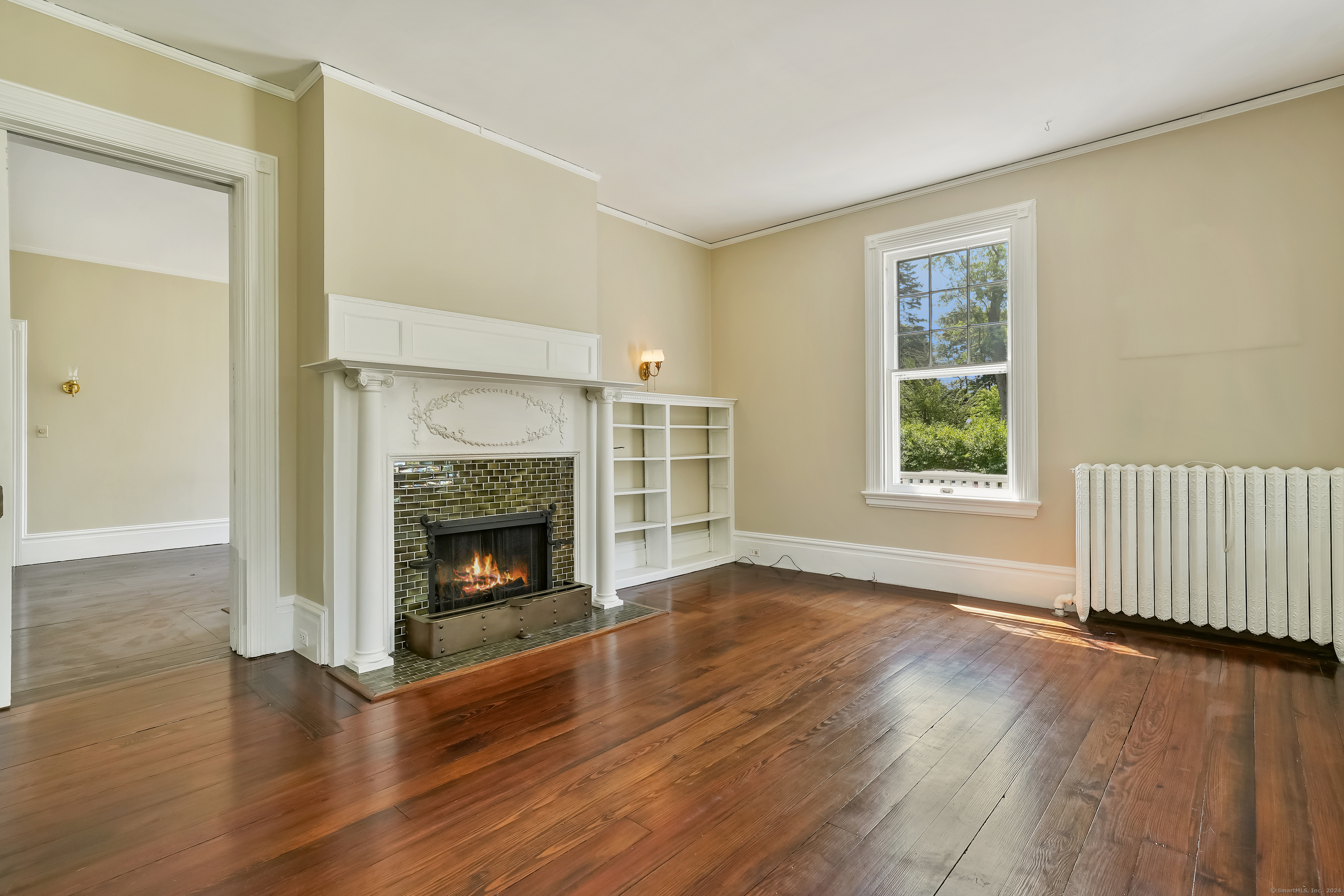56 East Ridge Road Ridgefield, CT 06877 - Photo 11 of 38 an empty room with wooden floor fireplace and windows