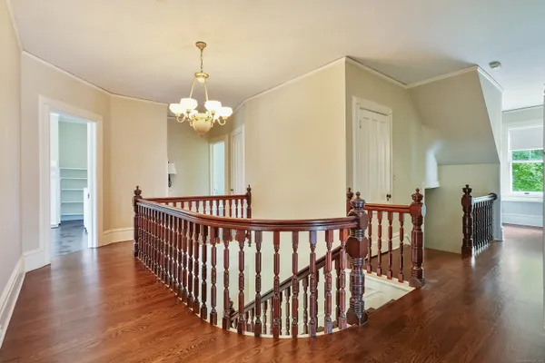 a view of a dining room with wooden floor windows and a chandelier